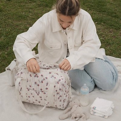 Sac a langer avec fleurs rouge maman regarde dans sac
